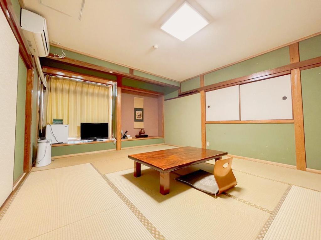 a living room with a wooden table and a window at Eimiya Ryokan - Vacation STAY 36320v in Amakusa