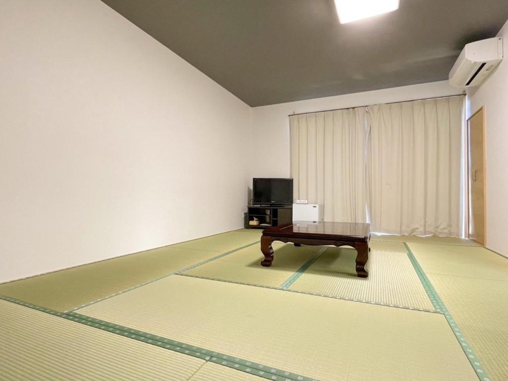 天草市にあるEimiya Ryokan - Vacation STAY 36348vのテーブルとテレビが備わる部屋