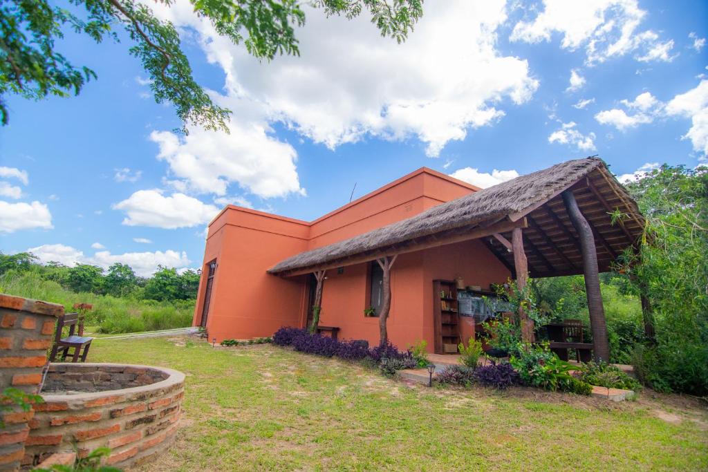 una pequeña casa naranja con techo de paja en IBL Guest House en Loreto