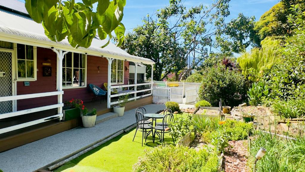una veranda di una casa con tavolo e sedie di The Garden Cottage a Tawonga