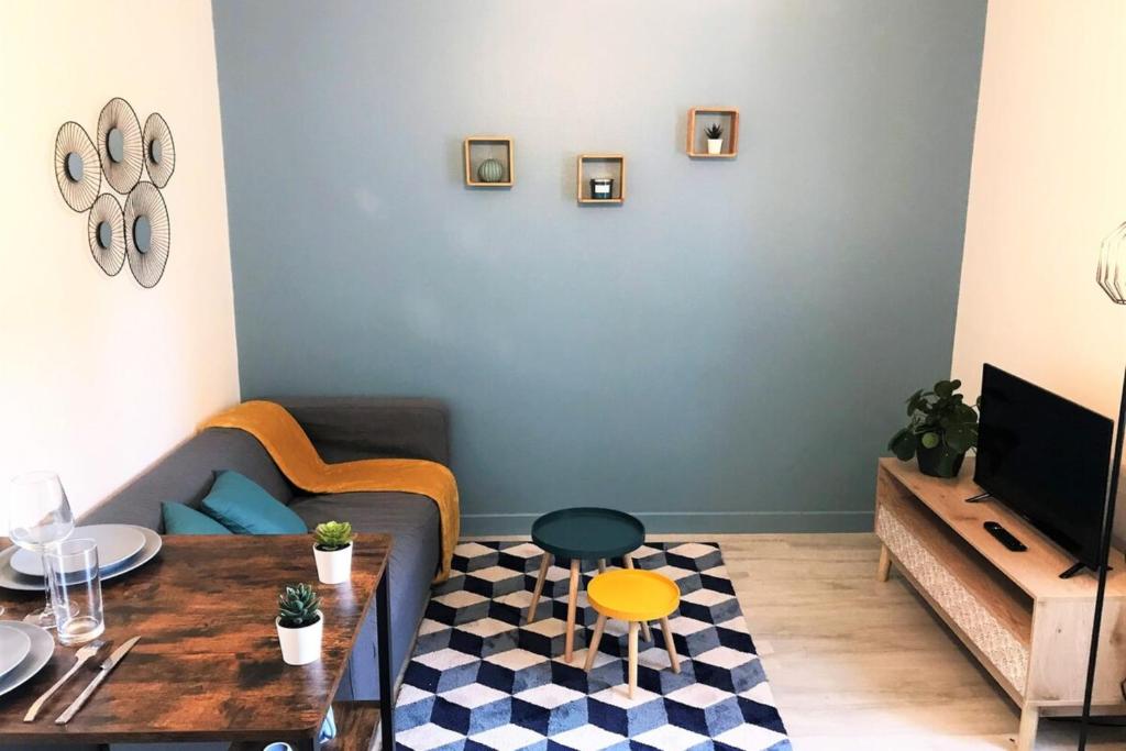 uma sala de estar com um sofá e uma mesa em Le Donatien-Cosy appart proche centre et Erdre em Nantes