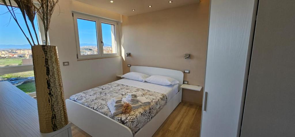- une chambre avec un lit et un vase dans l'établissement Happy Holiday Apartament Quartu Sant’Elena, à Quartu SantʼElena