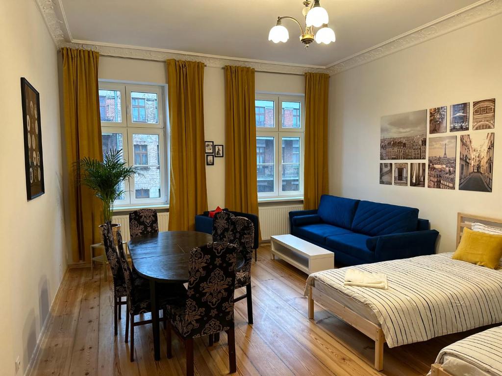 a living room with a table and a blue couch at Apartament Trzecie Piętro in Poznań