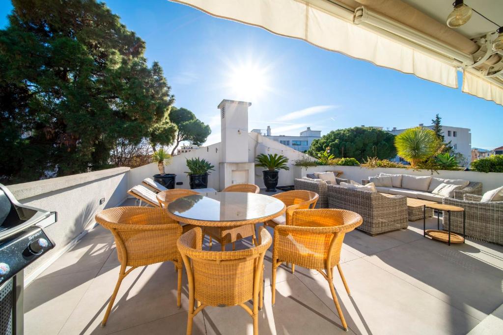 un patio avec une table et des chaises sur un balcon dans l'établissement Cannes Luxury Rental - Pretty 3 bedroom apartment to rent with 50m terrace, à Cannes