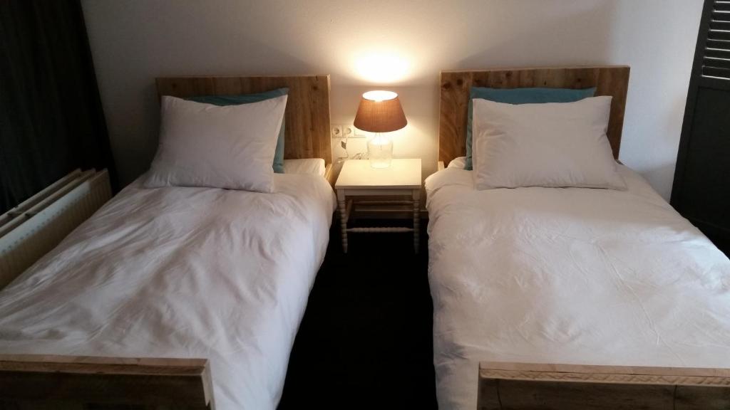 two beds in a room with two lamps on at Oekepoek Down Town in Enschede