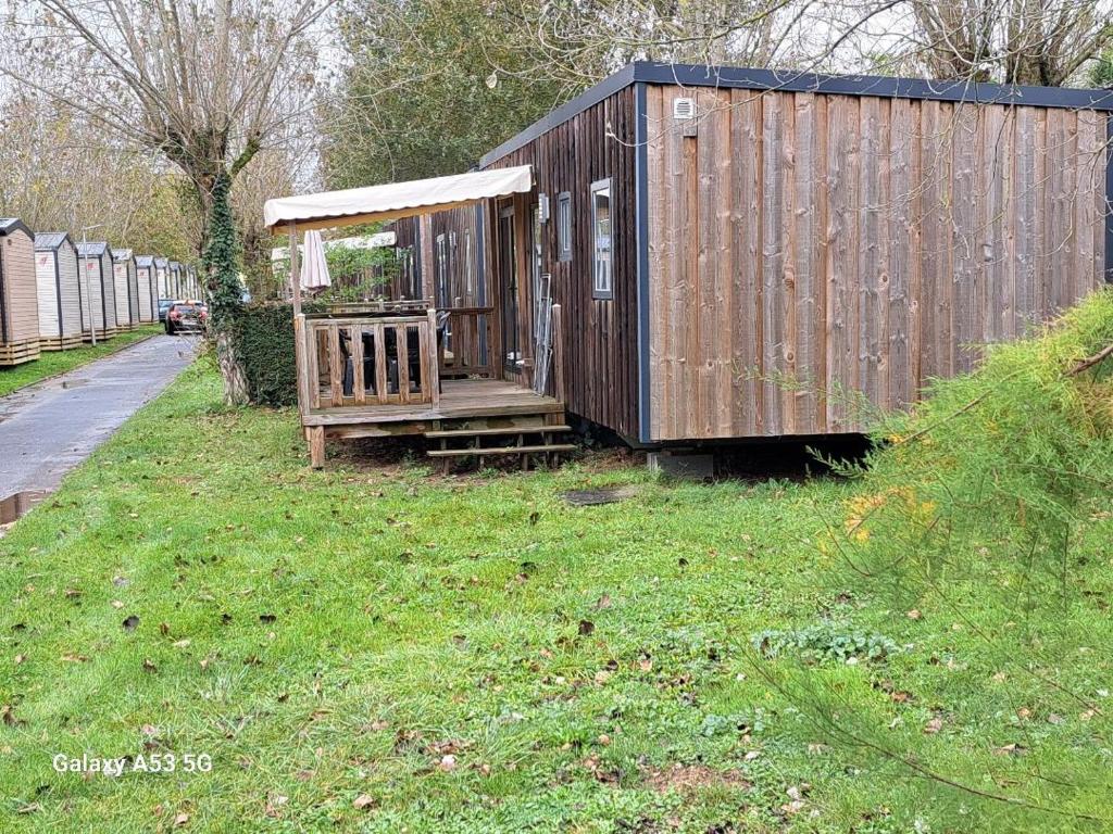 a small wooden shed sitting in a field of grass at RIVA BELLA MH 171 in Ouistreham