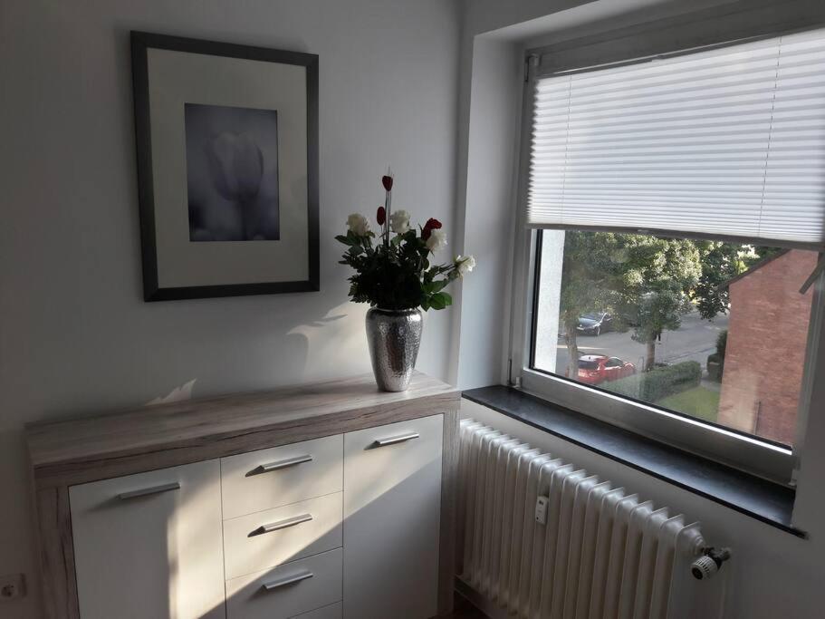 a vase of flowers sitting on a counter next to a window at Gemütliche Monteurwohnung in Oberhausen in Oberhausen