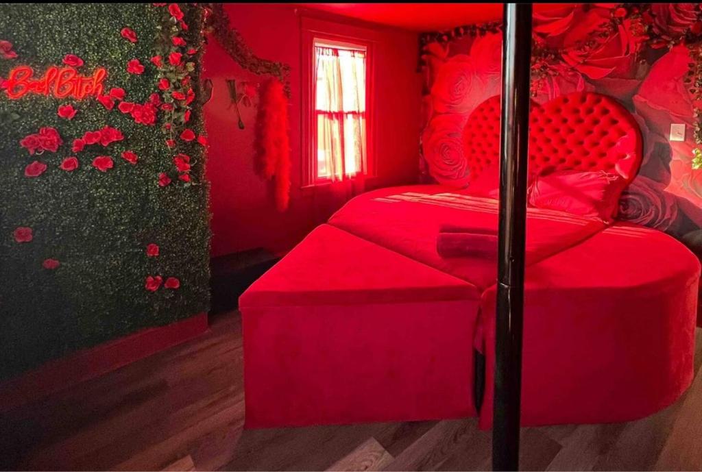 Un dormitorio rojo con una cama roja y una ventana en TheHottieHouse: Fun Fantasy Experience Apt On Blvd, en Filadelfia