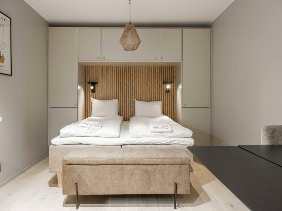 um quarto com uma cama grande e um repousa-pés grande. em Slopeside Serenity in Are Ski-in Ski-out Studio em Åre