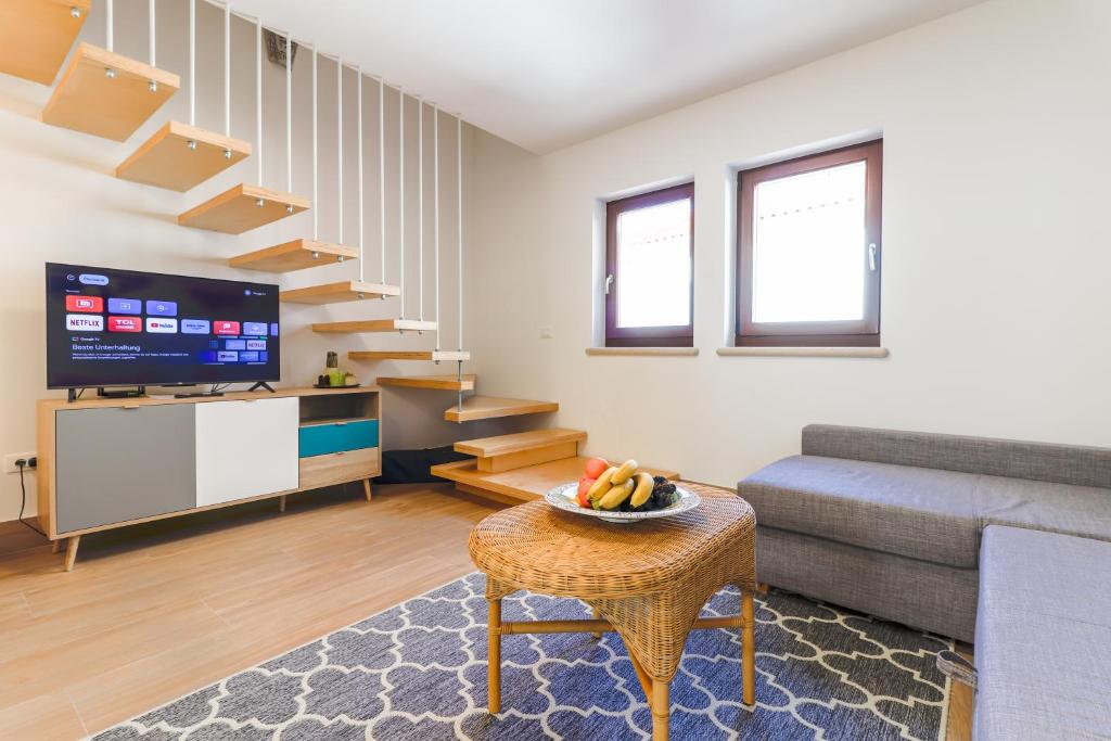 a living room with a staircase and a table at Casanova Apartments - Viewpoint in Vrsar