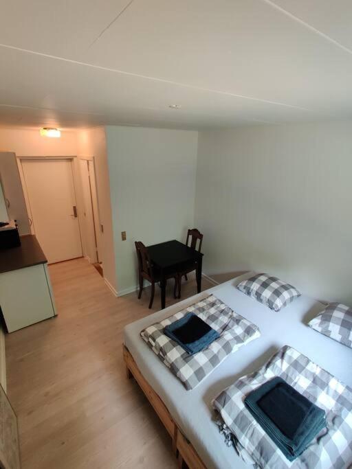 ein Schlafzimmer mit einem Bett und einem Tisch sowie ein Zimmer in der Unterkunft Nice Little centrum apartment! No.11 in Billund