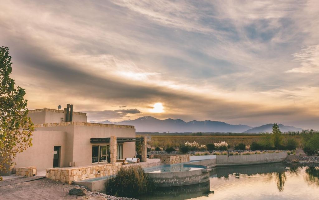 een huis met een rivier ervoor bij Rosell Boher Lodge in Agrelo