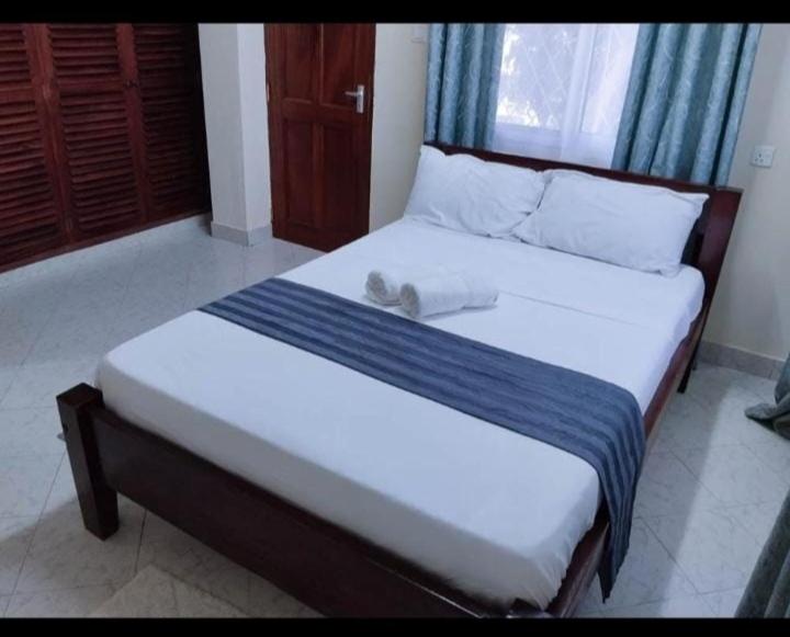 a bed with a towel on top of it at Chloe Isla 2 apartment Malindi in Malindi
