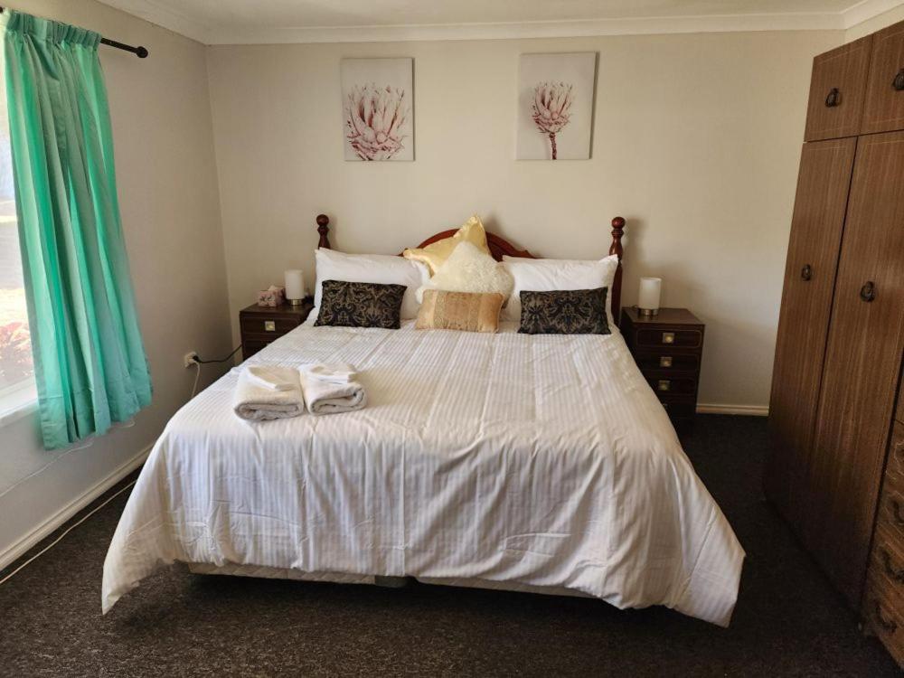 a bedroom with a white bed with two towels on it at Country Retreat The Blue Cottage in Gingin
