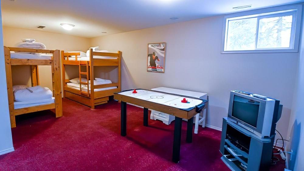 a room with a table and a tv and bunk beds at Polar Peak Chalet by Fernie Lodging Company in Fernie