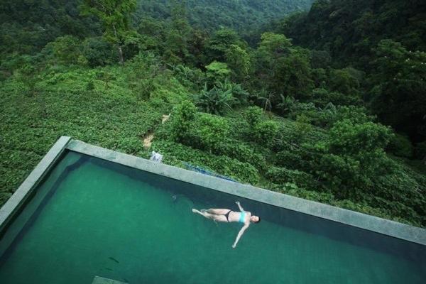 a person swimming in a pool of water in a forest at Villa Núi in Vĩnh Phúc