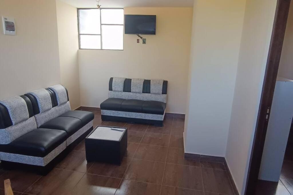 ein Wohnzimmer mit zwei Sofas und einem Tisch in der Unterkunft nuevo y hermoso departamento (9) in Sucre