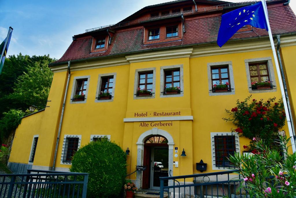 ein gelbes Gebäude mit einer Flagge davor in der Unterkunft Alte Gerberei in Bautzen