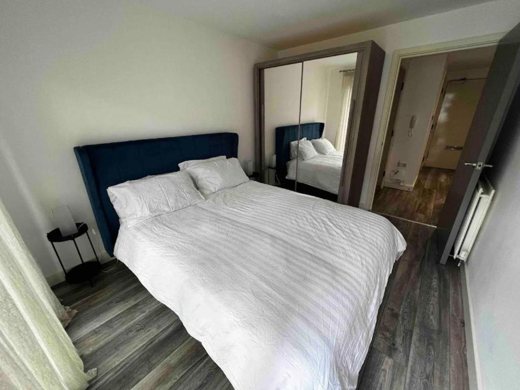 a bedroom with a large bed and a mirror at Stylish 1-Bed Flat with Sofa-Bed in London in London