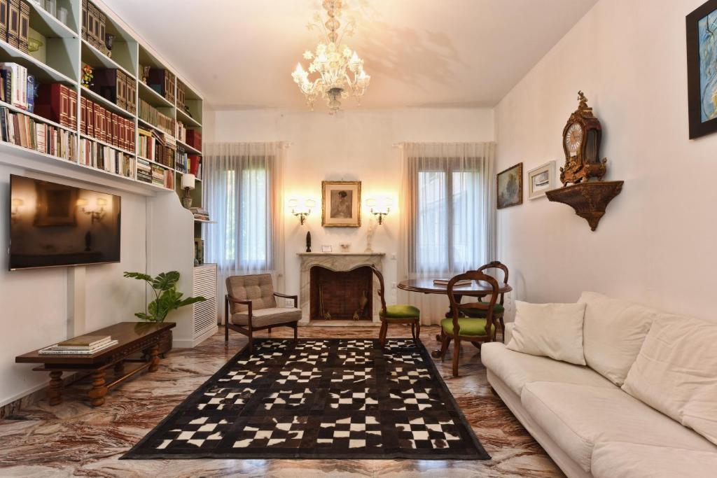 een woonkamer met een bank en een open haard bij Soderini Splendor: First Floor Palazzo Charm at Castello Square in Venetië