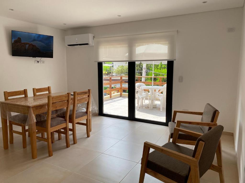 a dining room with a wooden table and chairs at Ubatuba Lofts Mar Azul - depto 2 hab in Mar Azul
