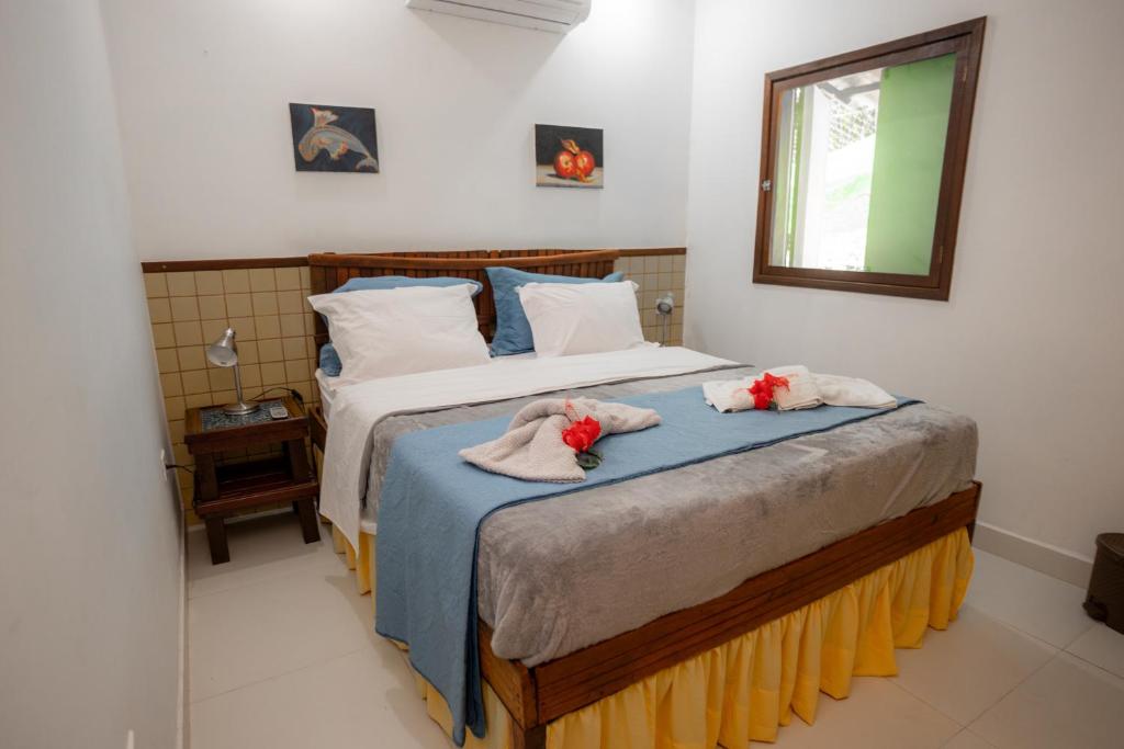 une chambre avec un lit avec des serviettes dessus dans l'établissement Casa da Marcia, à Fernando de Noronha