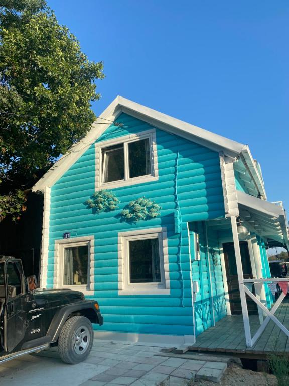 een blauw huis met een auto ervoor geparkeerd bij Stella Marina in Pržno