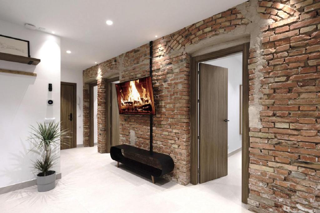 sala de estar con pared de ladrillo y chimenea en Luxury flats PCL by Clabao, en Logroño