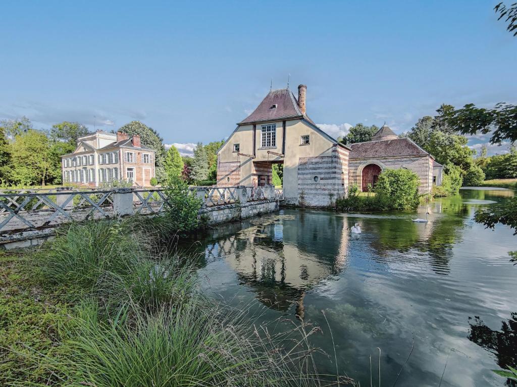 un puente sobre un río con casas y edificios en Château de Luzières, en Conty