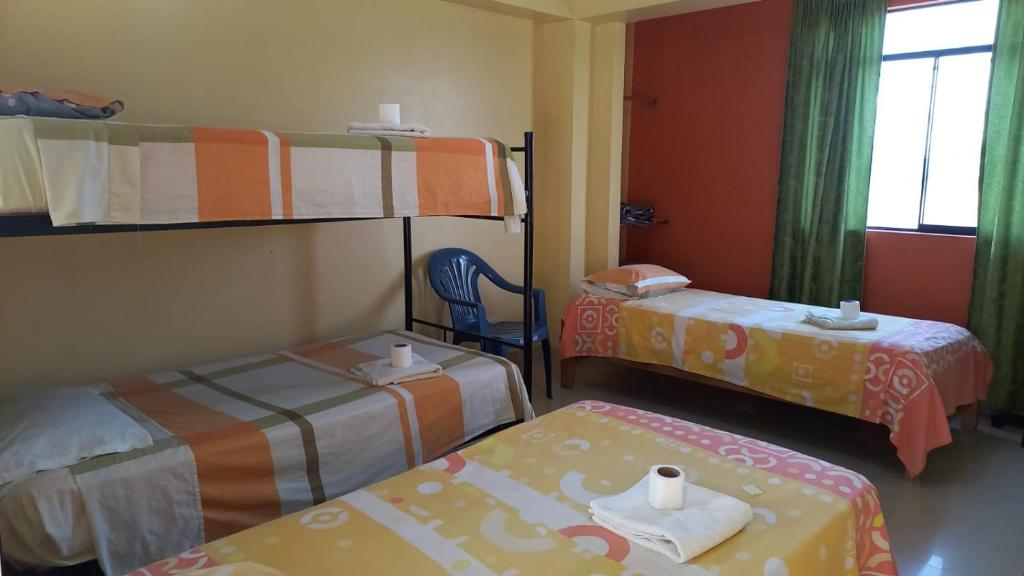 皮斯科的住宿－Hospedaje Huamani & Mi Casa，带两张双层床和椅子的房间
