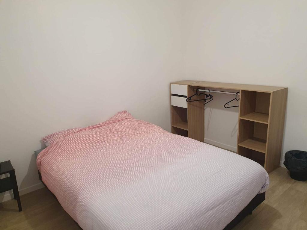 niewielka sypialnia z łóżkiem i biurkiem w obiekcie Gîte Bamas w mieście Saint-Dizier