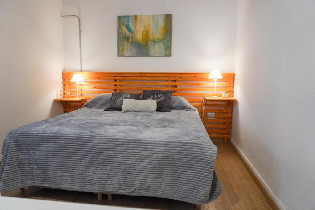 a bedroom with a large bed with two lamps at Solar del Tajamar in Alta Gracia