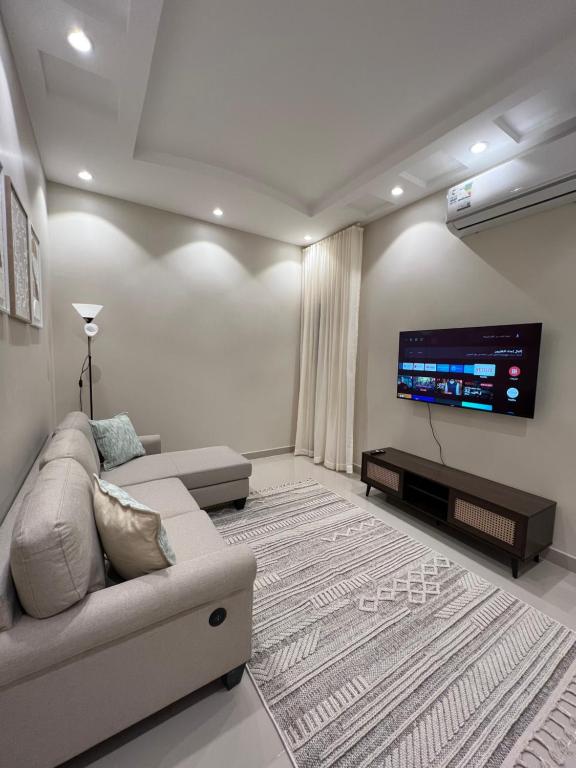 sala de estar con sofá y TV de pantalla plana en Al Malqa Haven - الملقا - الرياض, en Riad