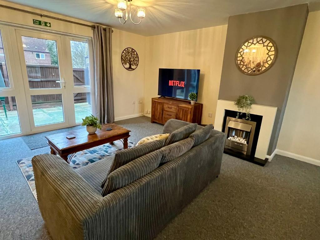 ein Wohnzimmer mit einem Sofa und einem TV in der Unterkunft Middleton House in Norwich
