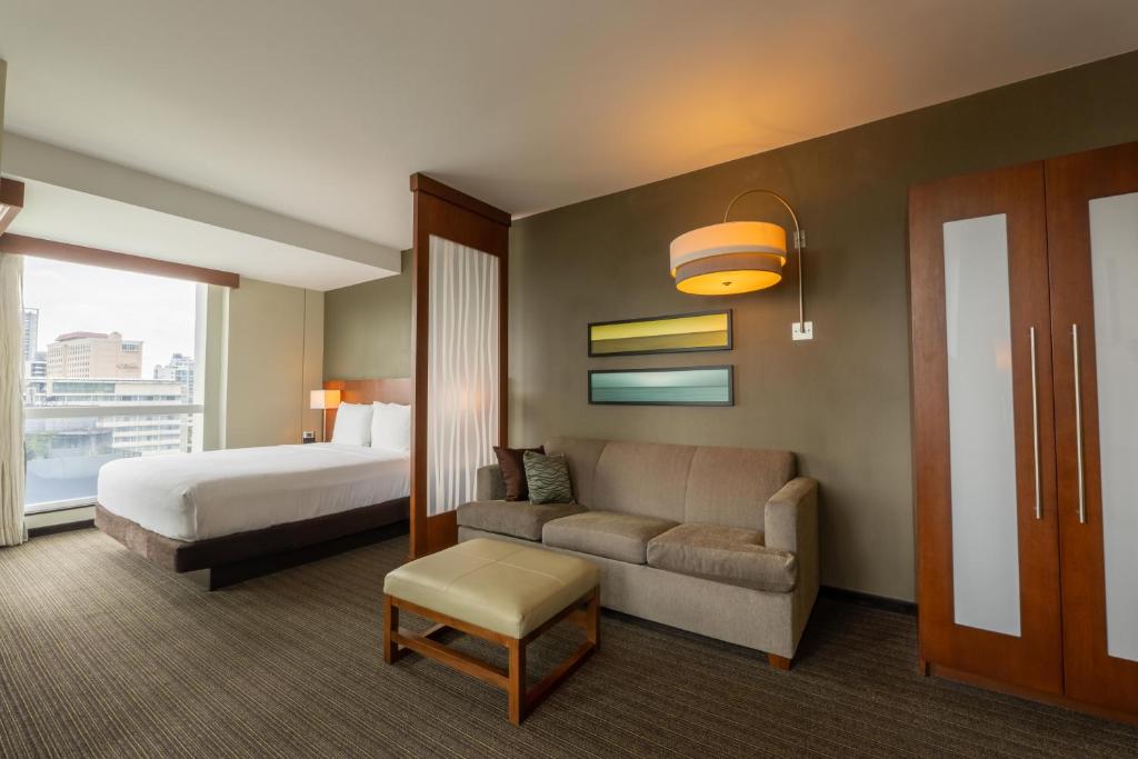 une chambre d'hôtel avec un lit et un canapé dans l'établissement MARINN PLACE Financial District, à Panama City