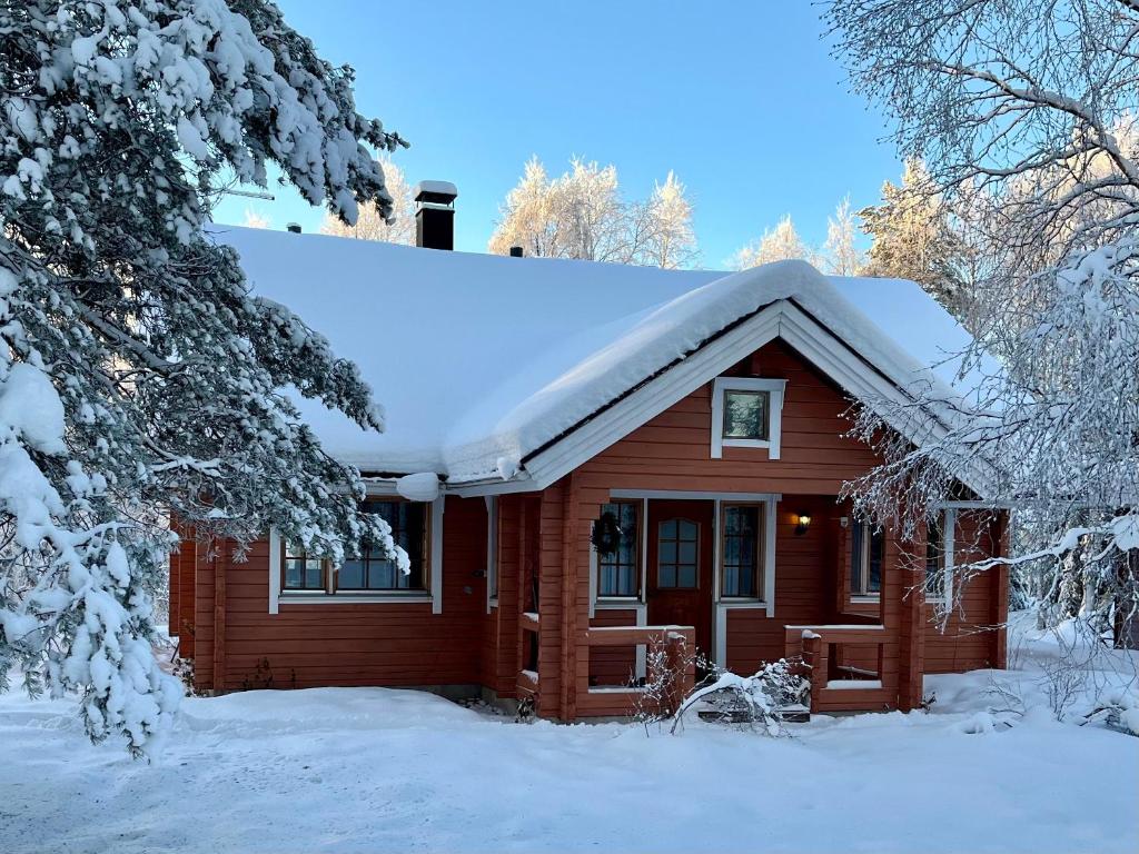 a wooden house with snow on the roof at Log cabin in 15 min from Rovaniemi center- 3bdr-Sauna-Fireplace in Rovaniemi