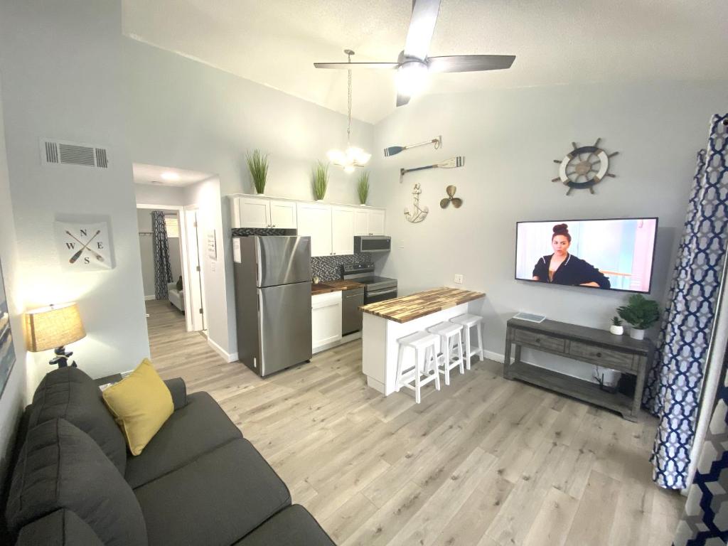 a living room and kitchen with a couch and a tv at B Lakefront! Remodeled, Boat Slip, Patio Views, Pool, Boat Ramp, WIFI in Osage Beach