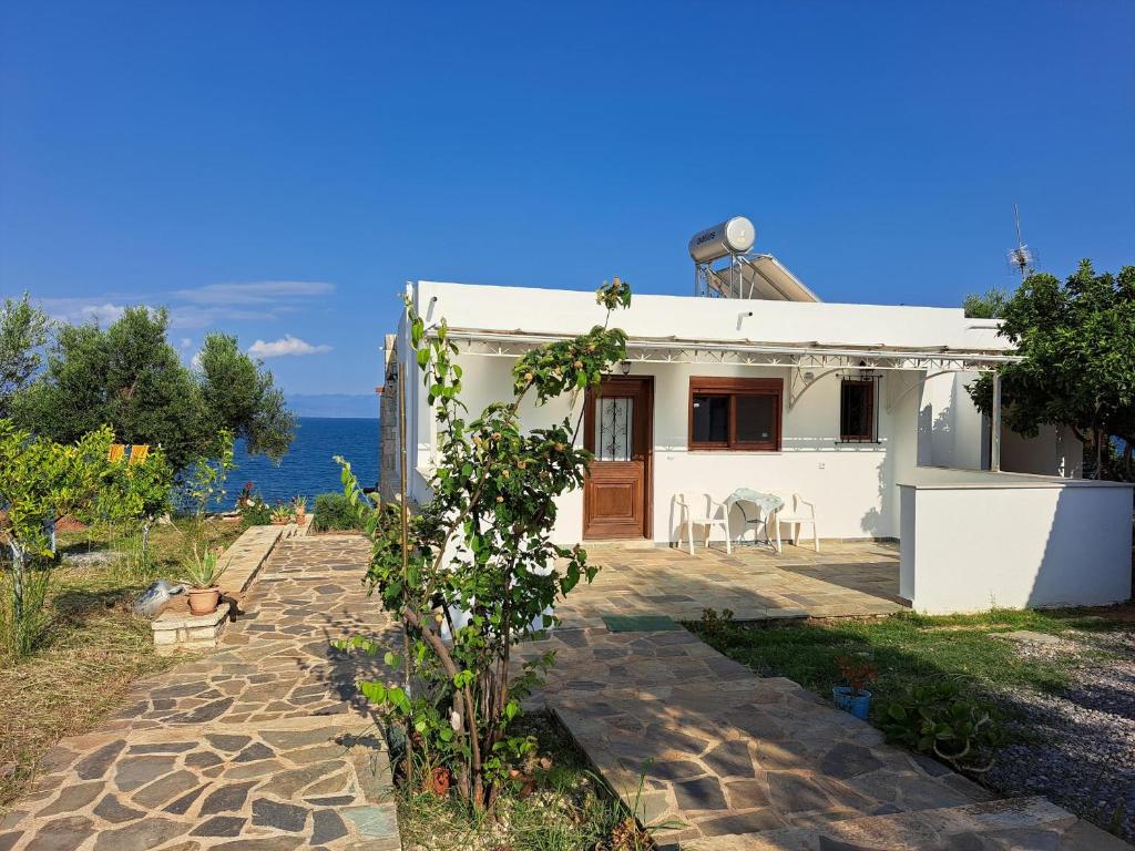 a white house with a patio and the ocean at Blue Fox 3 in Chrani