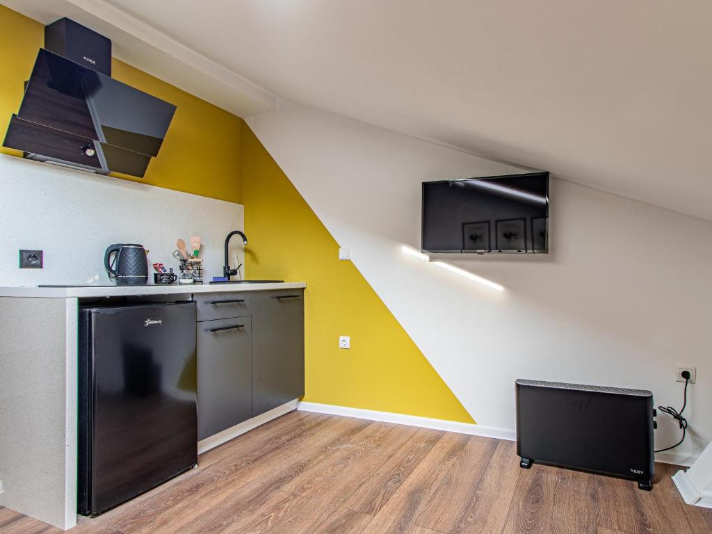 a kitchen with a yellow and white wall at Vazov Loft - Central Sofia Studio in Sofia