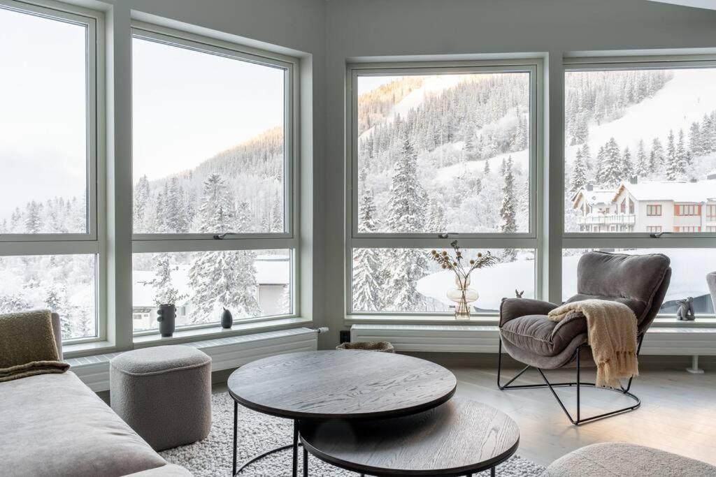 a living room with a couch and a table and windows at Slope-Side Bliss 8-Guest Apt in Åre