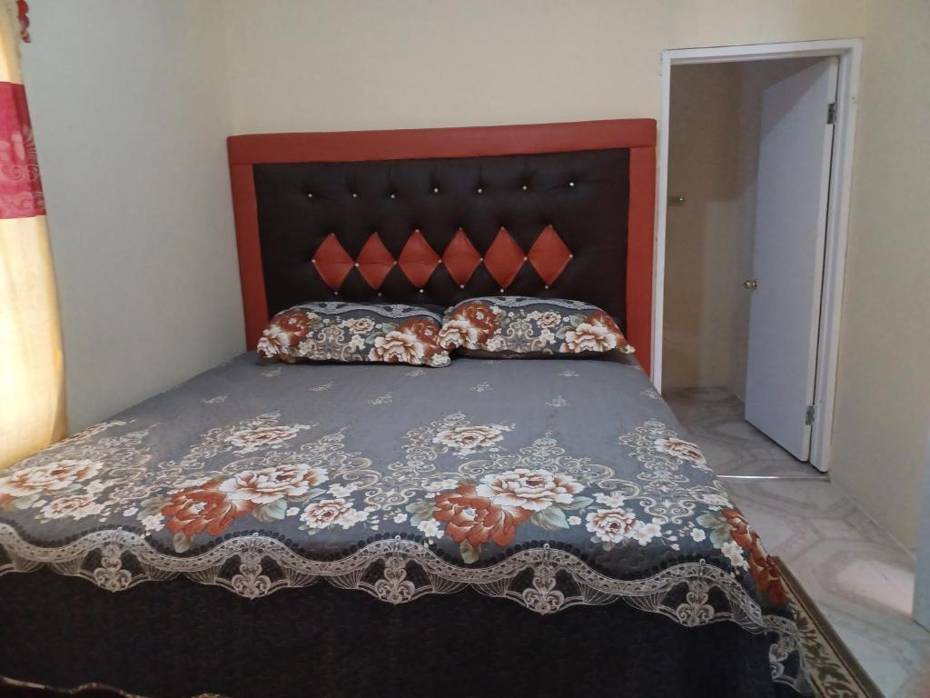 a bed with a red headboard and pillows on it at 1 bdrm1 1 bath in Old Harbour