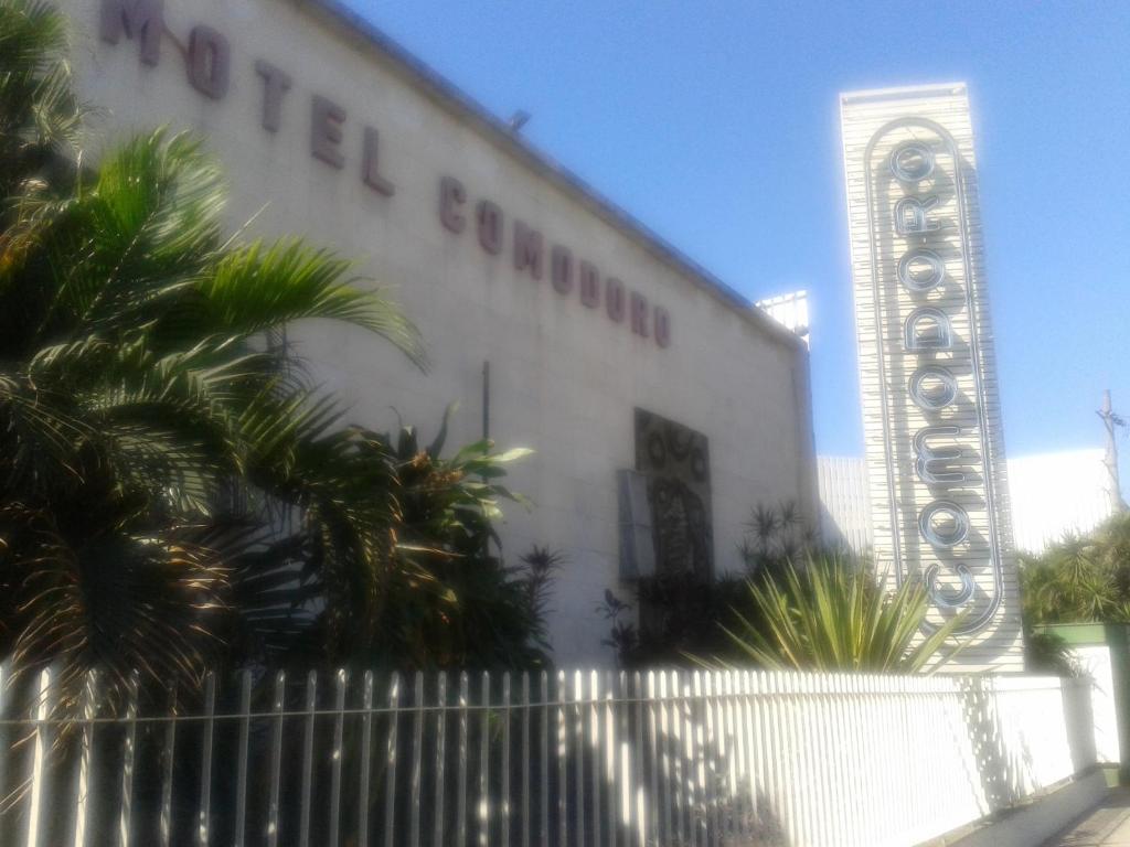 un bâtiment blanc avec un panneau sur son côté dans l'établissement Motel Comodoro (Adult Only), à Rio de Janeiro