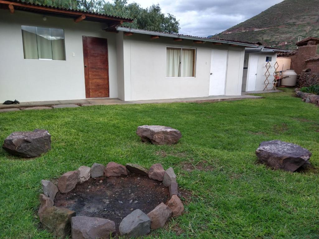 a yard with rocks in front of a house at Casa con jardín y vista a las montañas Pisac in Pisac