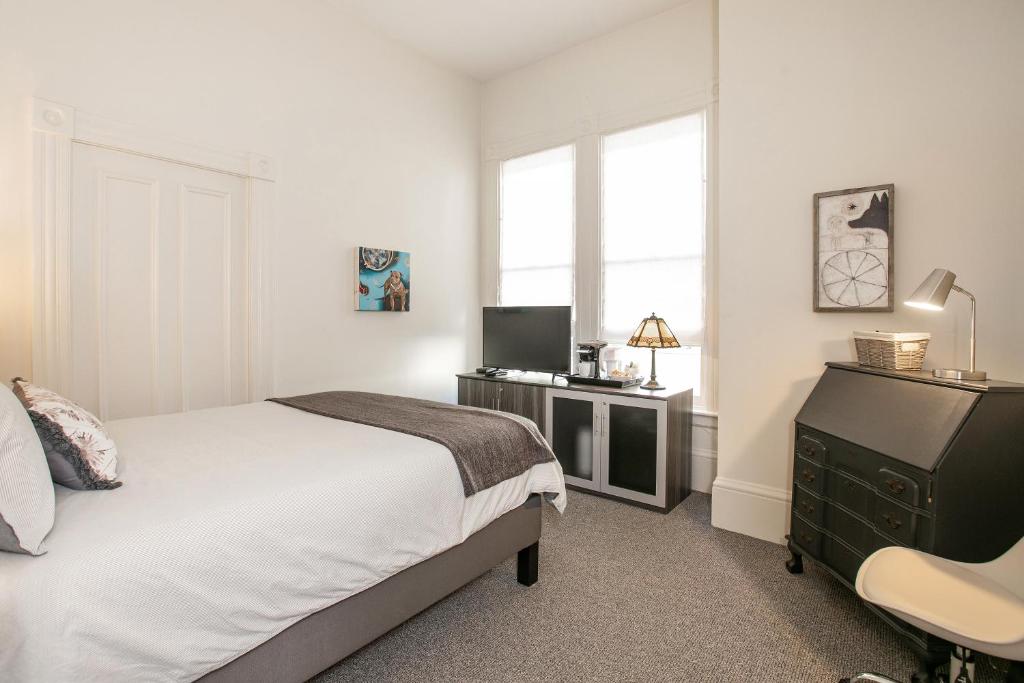 Dormitorio con cama, escritorio y TV en Pacific Heights Victorian Bedroom and Bathroom, en San Francisco