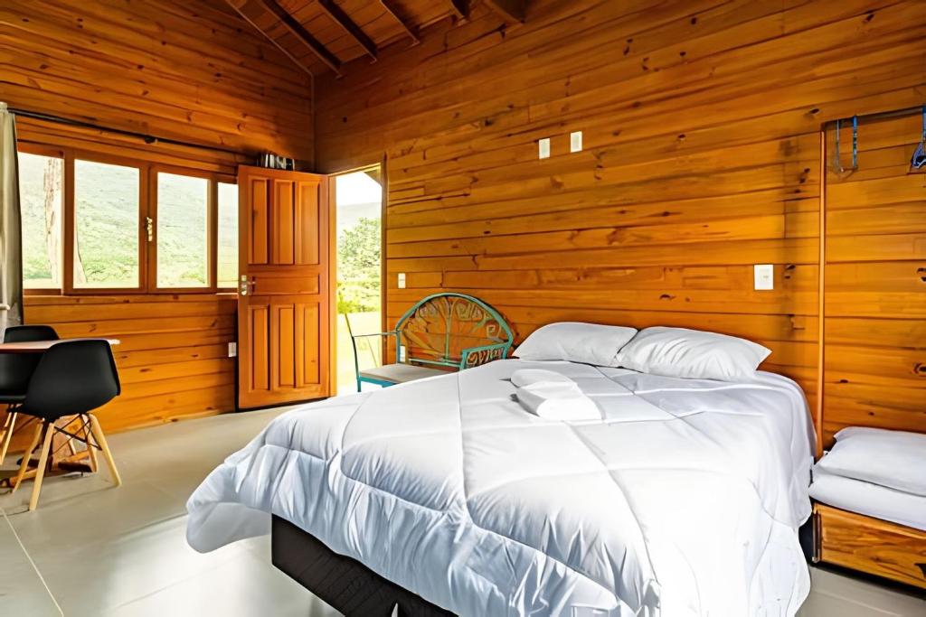 um quarto com uma cama numa parede de madeira em Cabanas aconchegantes. Desfrute da natureza e praia em Florianópolis