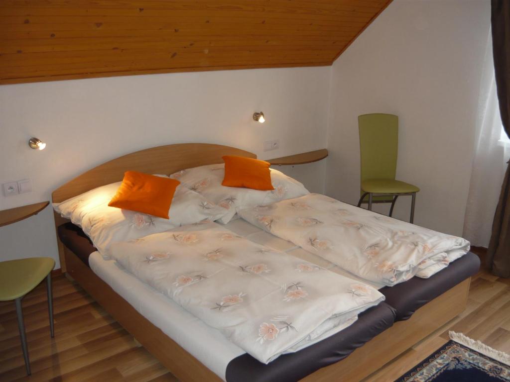 a bed in a small room with orange pillows on it at ubytovanie michaela in Liptovský Michal