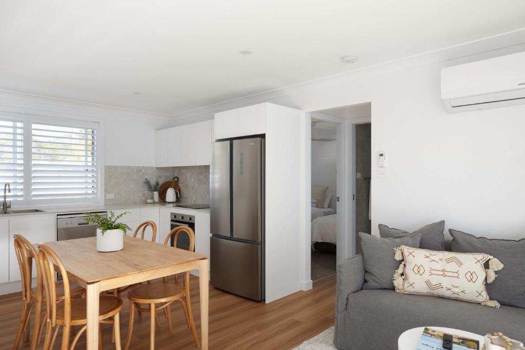 een keuken en woonkamer met een tafel en een bank bij No 2 Luana in Nelson Bay