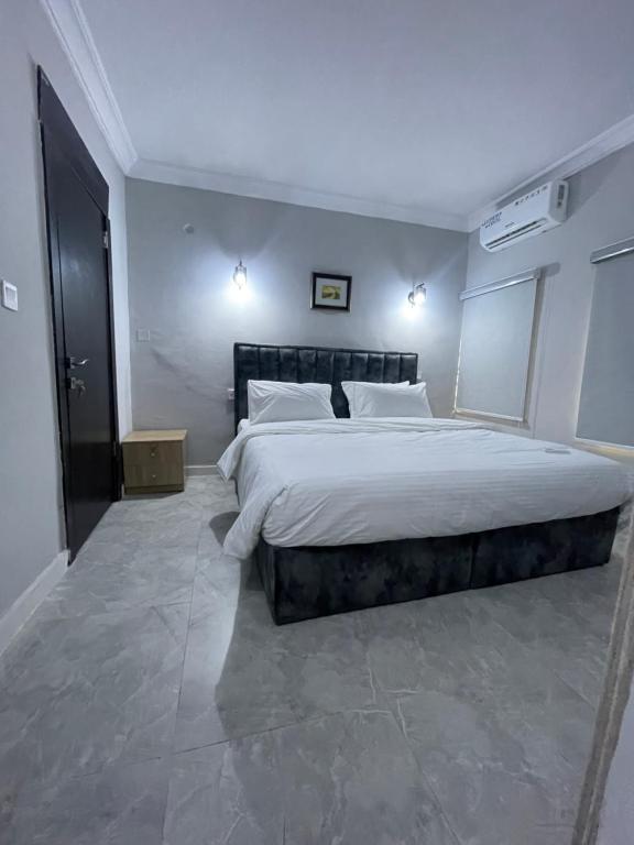 ein großes Schlafzimmer mit einem großen Bett mit weißer Bettwäsche in der Unterkunft Plot 100 in Lagos