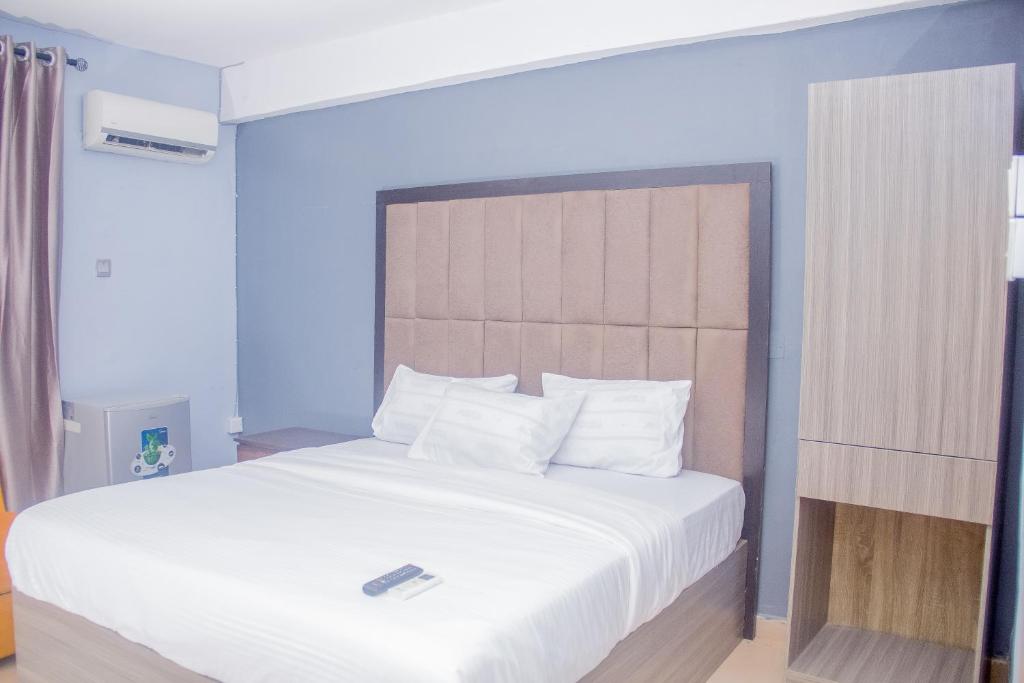 sypialnia z dużym łóżkiem z białą pościelą w obiekcie MORADA HOTELS LTD w mieście Lagos
