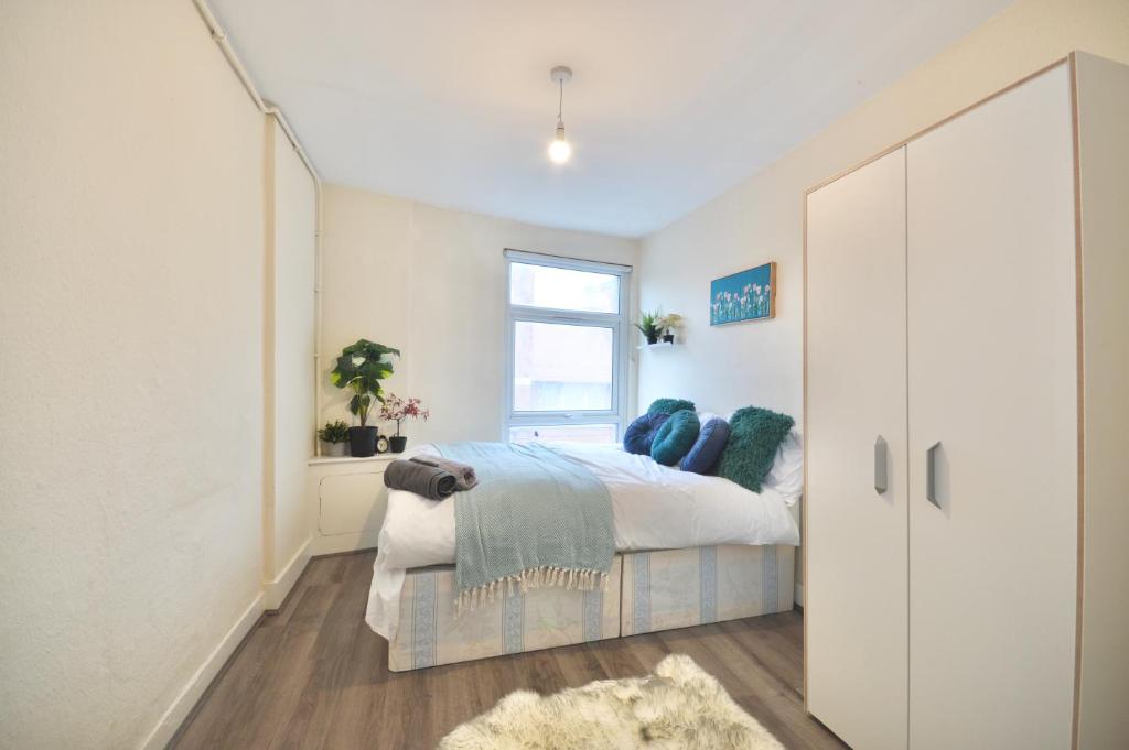 a bedroom with a bed and a window at Curve Apartments in London